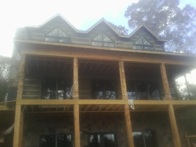 Dormers and porch framing on a large log home under construction — Roof Coating work by our crew in Sparks